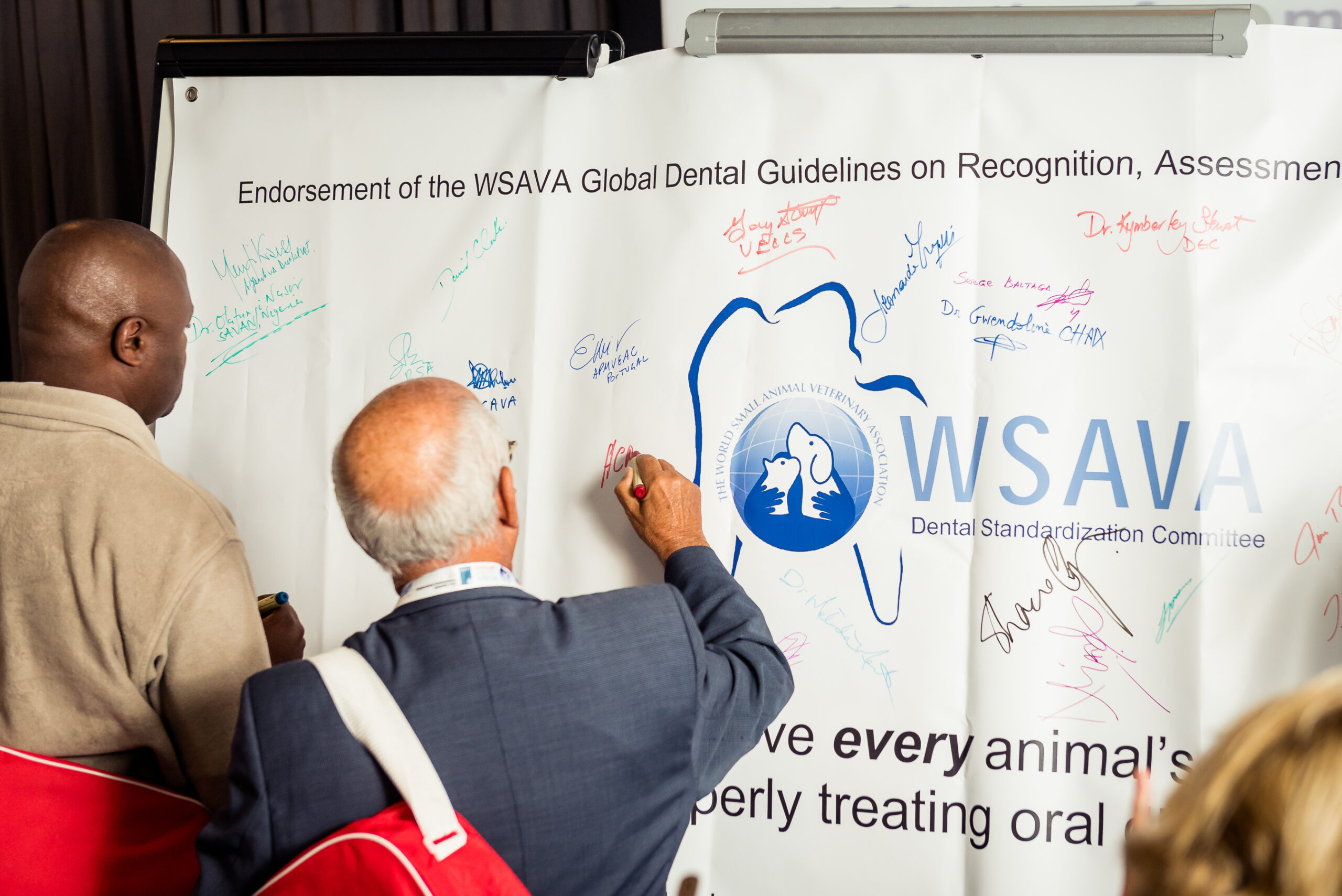 Assembly members signing the banner