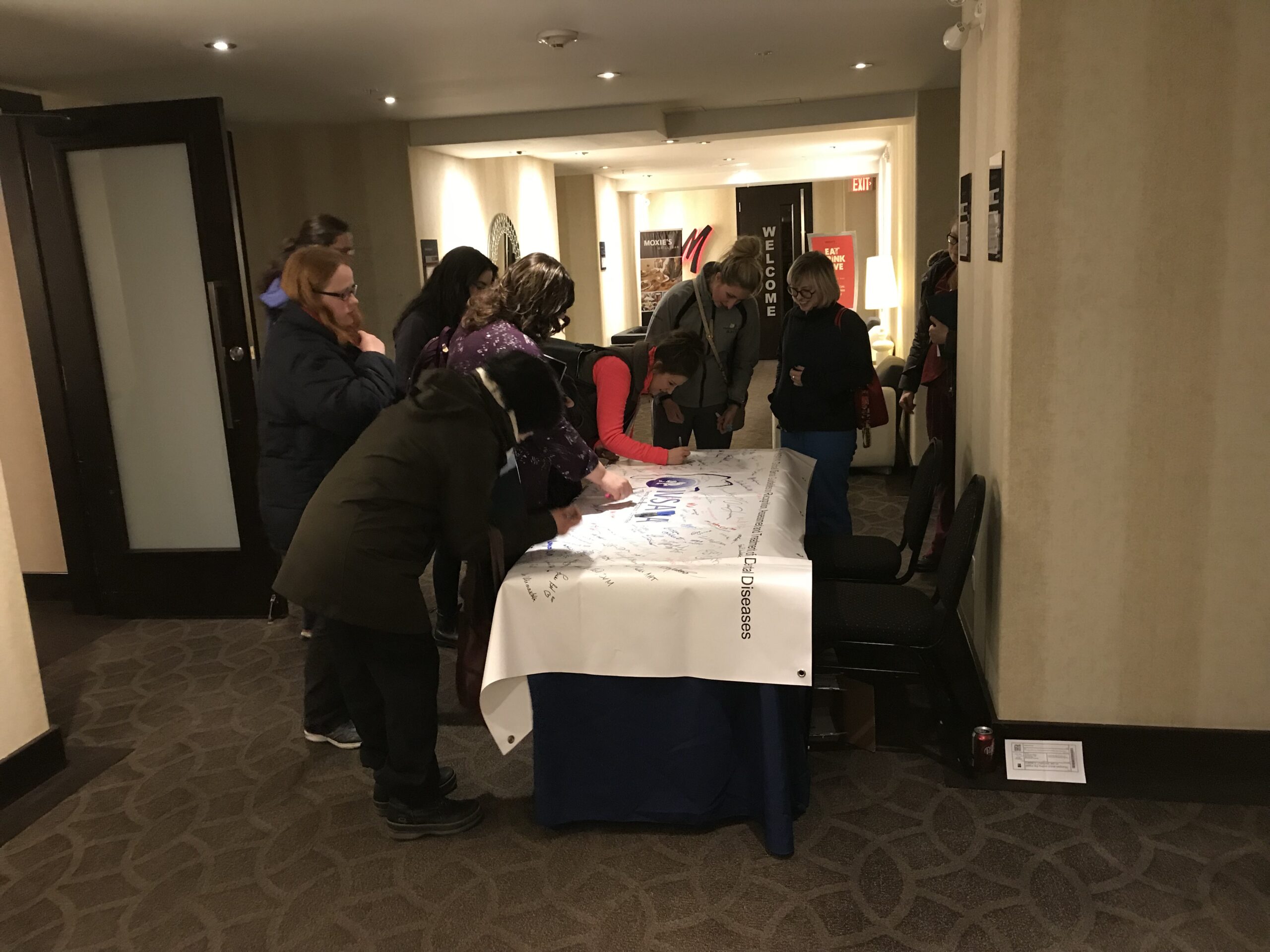Attendees from the Calgary event signing the banner